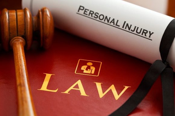 Inspector. Graphic logo is my artwork. Thanks. Red leather Personal Injury Law book and gavel with gold embossed type and stylised icon of figure with arm in a sling embossed on the book cover and a Personal Injury writ.
